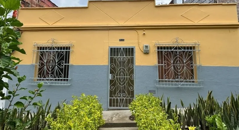 Fachada de la Casa de Amalia, amarilla con rejas blancas