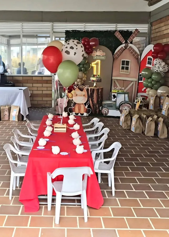 Mesa de fiesta con mantel rojo y sillitas